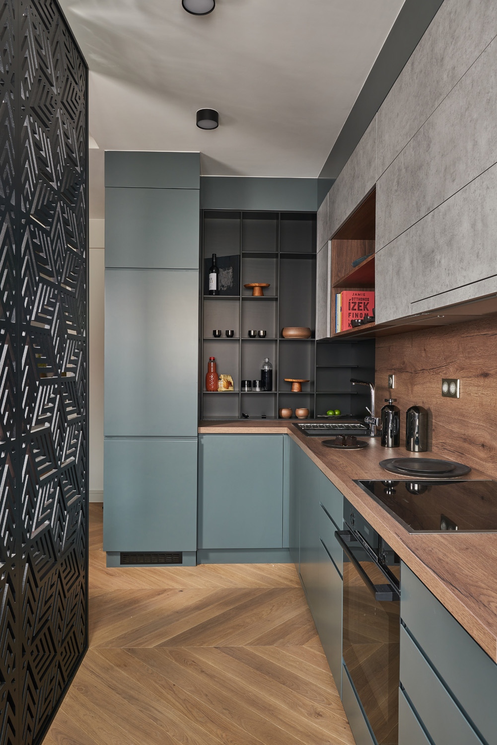 A pultok és frontok színének és textúrájának változatossága mozgatja meg a modern, beépített konyhabútort, ami tökéletesen kihasználja a rendelkezésére álló, hosszúkás teret