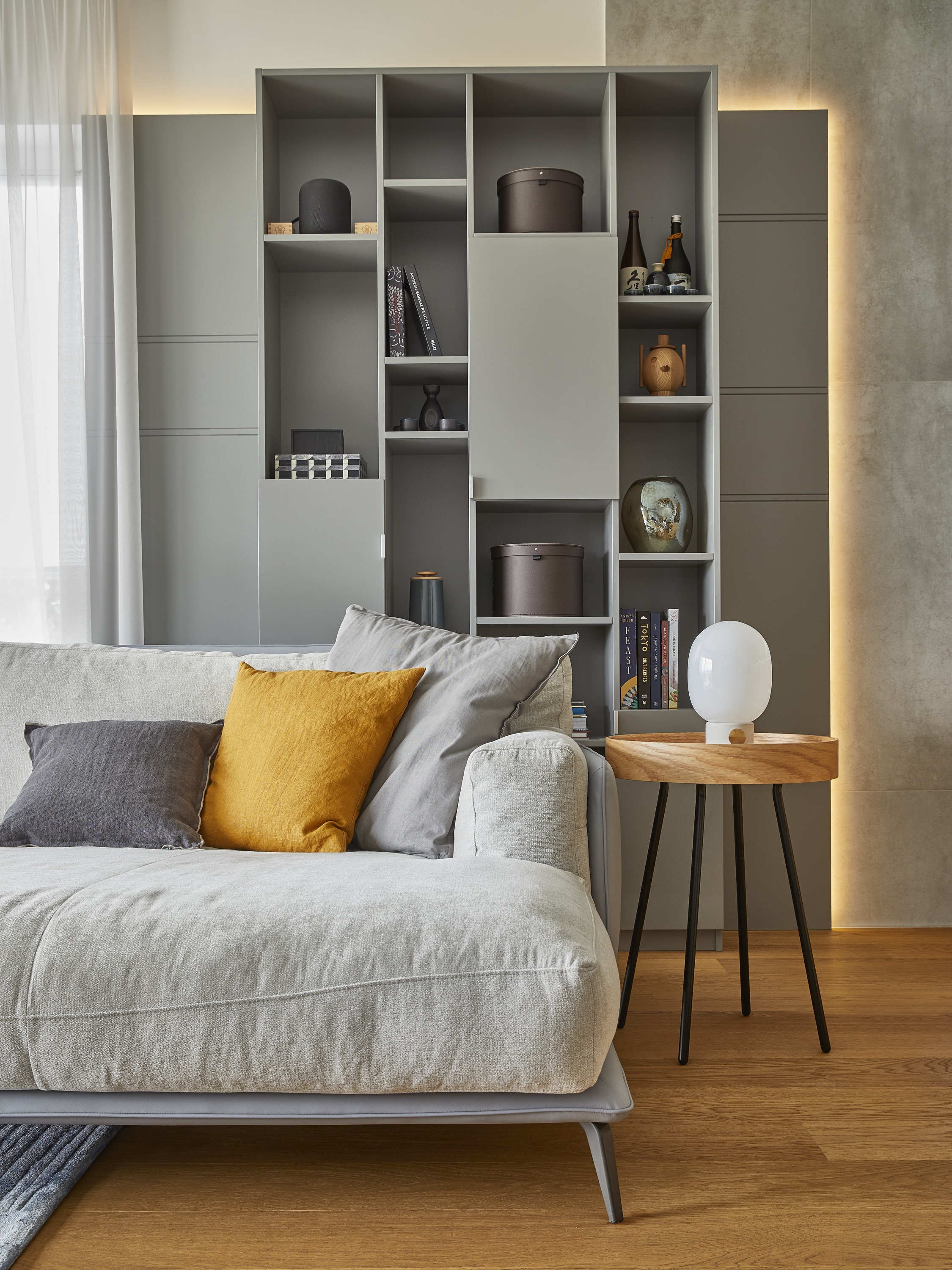 A nappaliban meghatározó szerepet kap az egyedi tervezésű, látványos polcrendszer saját megvilágí - tással és az alacsony, natur színű, kényelmes kanapé. 