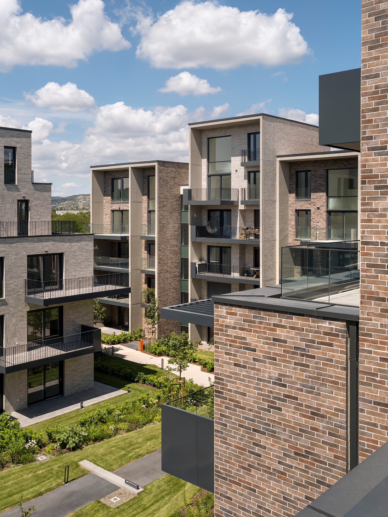 Az épületegyüttes magasház típusa legfelül a különleges duplex lakásoknak nyújt óriási megnyitásokat, kapafalaival pedig árnyékot és fedést a terasznaka