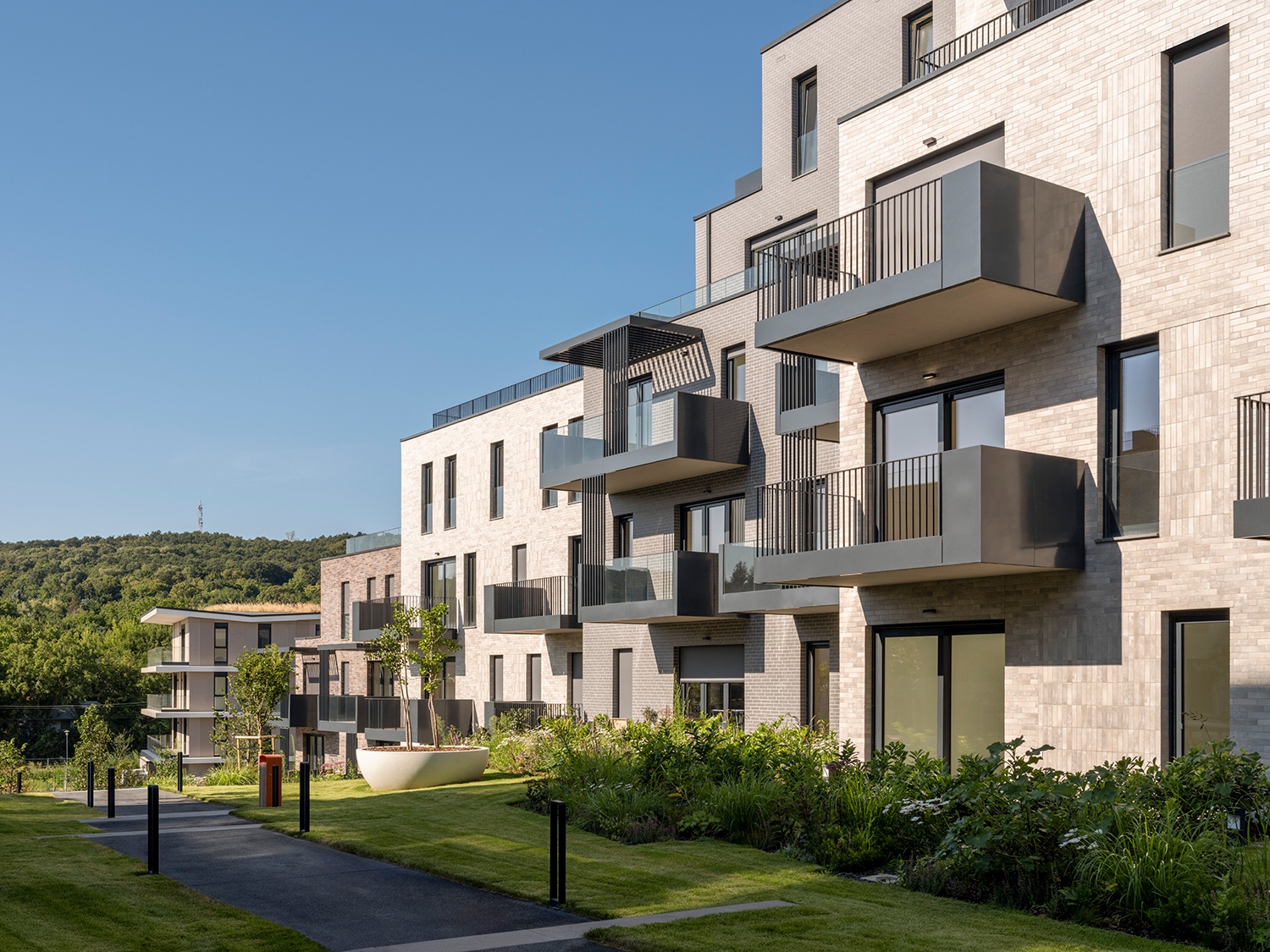 A park köré épülő struktúrák a legmozgalmasabbak. Az élhetőbb, minél több megnyitással rendelkező lakások eredménye ez, de a tömegalakítás mellett a homlokzati burkolatok is változatossággal lepik meg a szemet