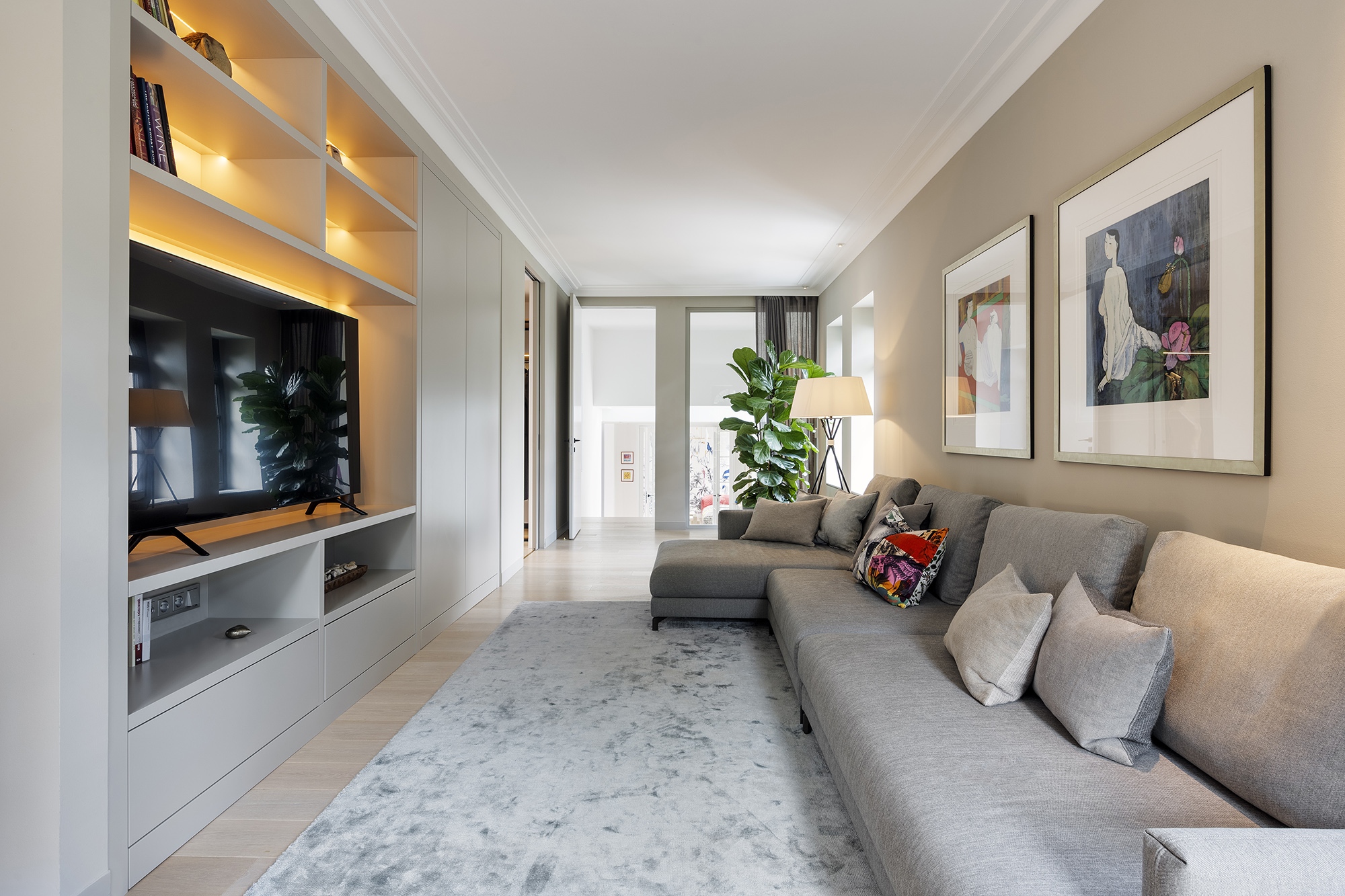 A szülők hálószobájához kapcsolódó nappali, bár szerényebb belmagasságú és méretű, ugyanazt a kifinomult, modern eleganciát hozza, mint a lakás többi helyisége.