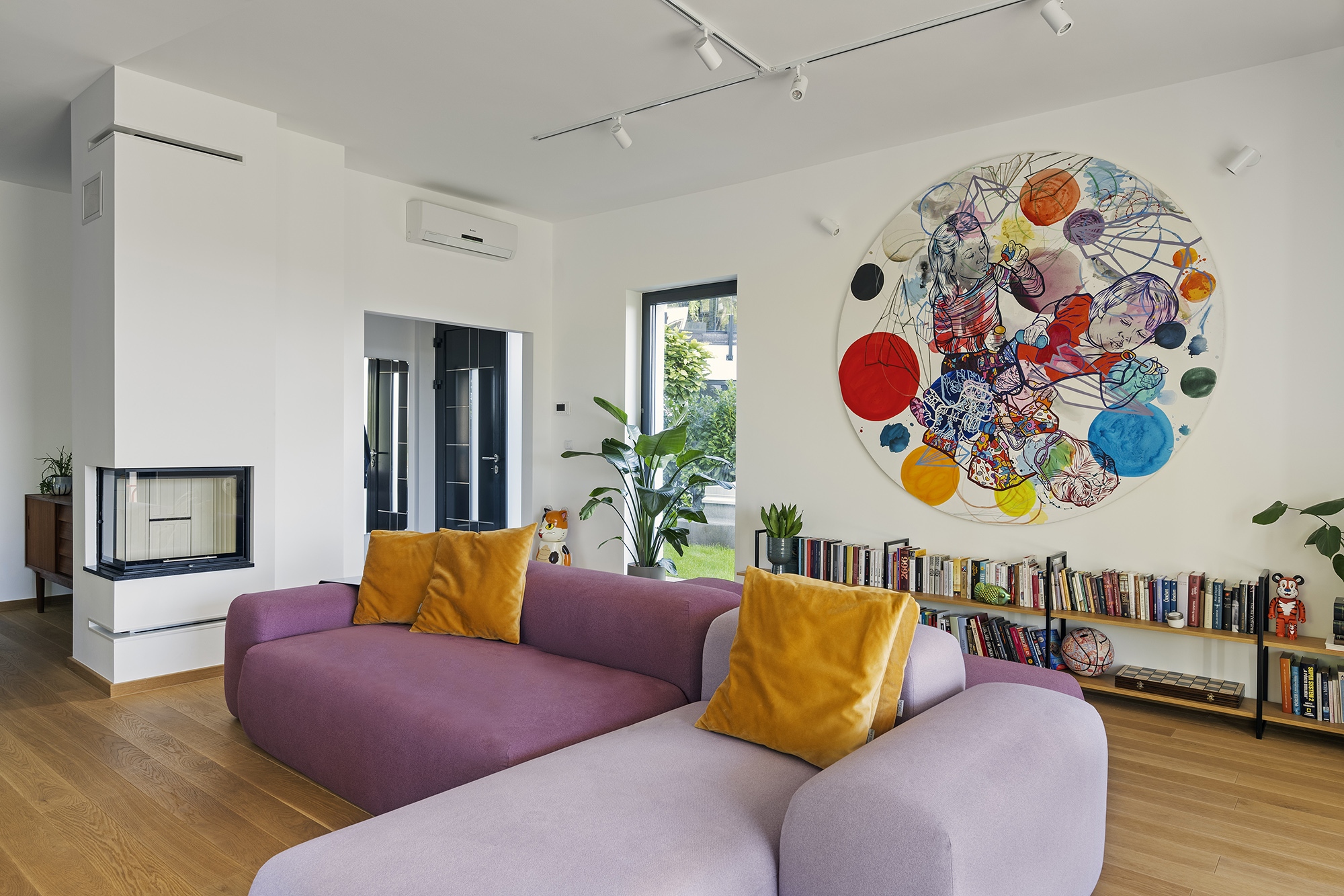 A nappali domináns eleme és egyben üde színfoltja az egyedi – igény szerinti töltésű és keménységű – moduláris kanapé, valamint Soós Nóra nagyméretű festménye