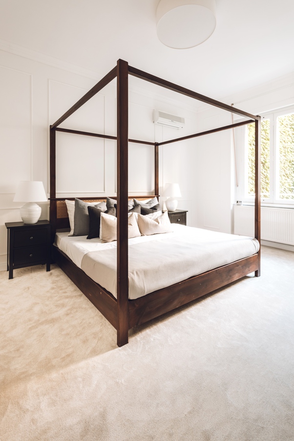 A tulajdonosok már meglévő baldachinos ágya. Ez a modern, mélybarna darab inspirálta a lakás többi sötétebb tónusú bútorát is – a hálót grandiózus krémszínű szőnyeg teszi intimebbé.