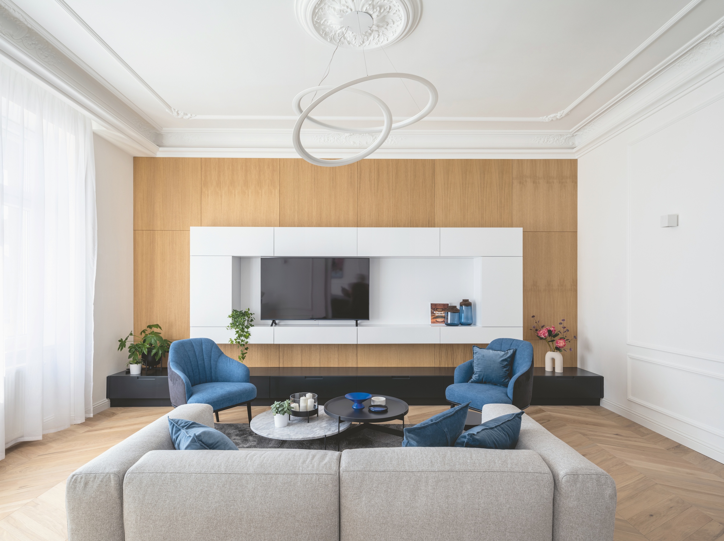 Nappali egy 13. kerületi magánlakásban, modern és klasszikus elemekkel, egy-egy fókuszponttal, amit itt a nappali tévéfala határoz meg – Fotó: Palkó György