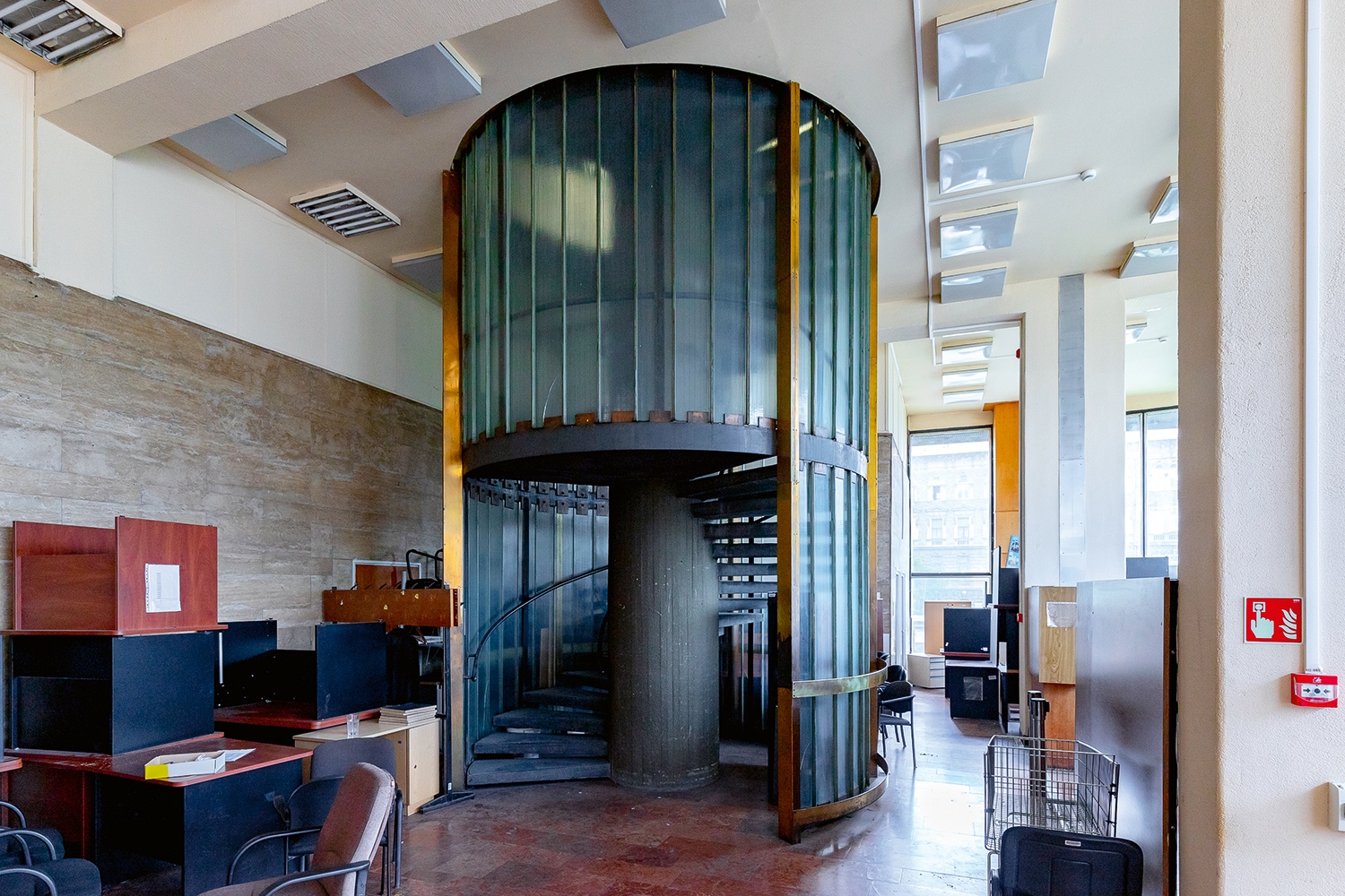 A közlekedő részek a központi mag köré csoportosultak, így az üvegbetonnal burkolt, íves lépcsősor és a liftek, köztük a még most is működőképes páternoszter is. Az alagsorban alakították ki az irattárat. (Fotó: Vékony Zsolt)