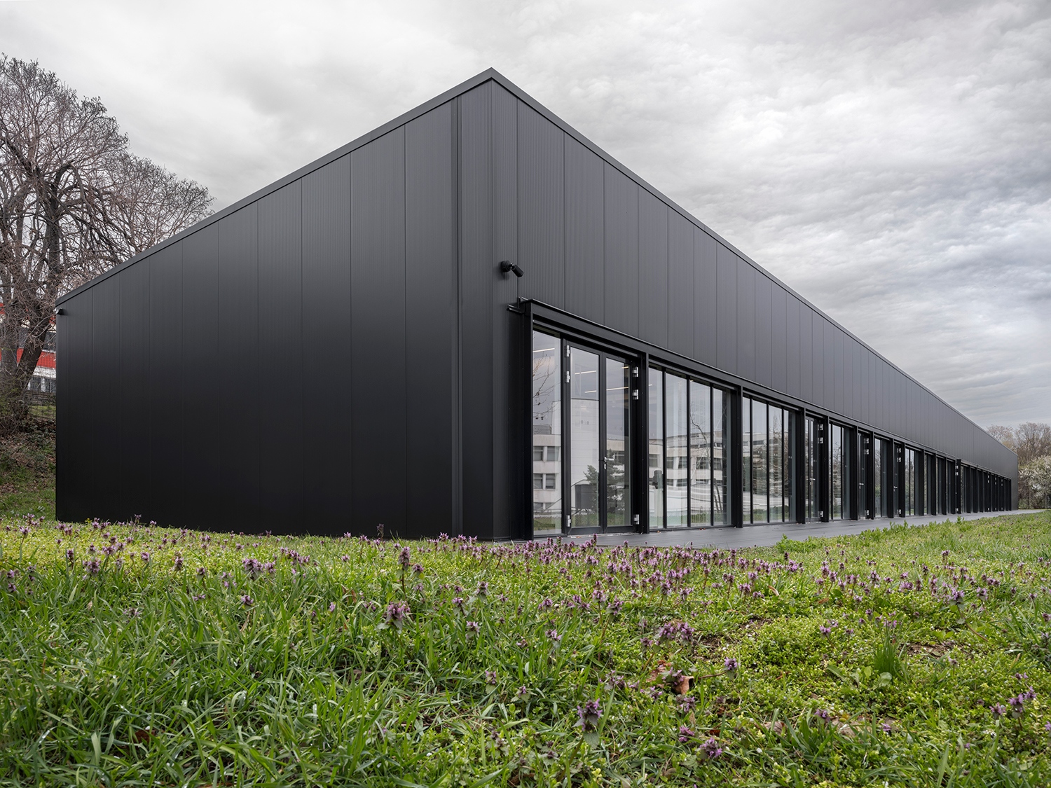 A szendvicspaneles csarnoképületet úgy tervezték, hogy a rendelkezésre álló pénzkeret függvényében mindkét oldalról egy-egy ötméteres raszterrel csökkenthető legyen a hossza