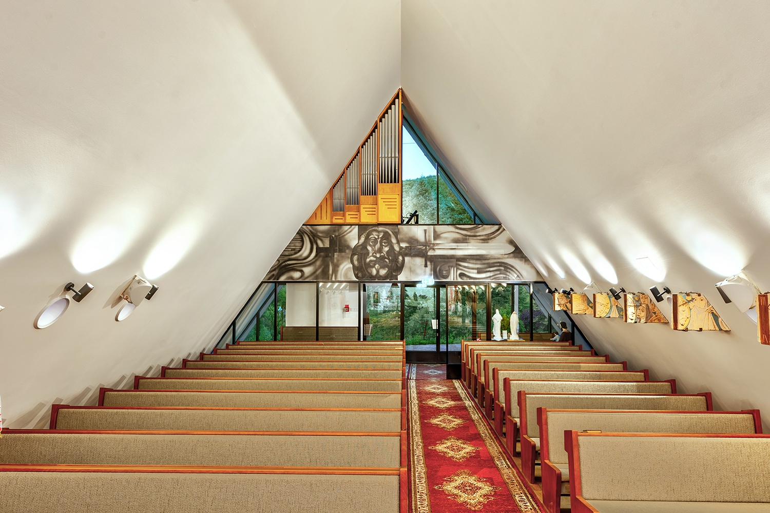 A különböző szélességű és magasságú háromszögekből formált halmazok, és a templomtér belső felépítése is a szentháromságra utal