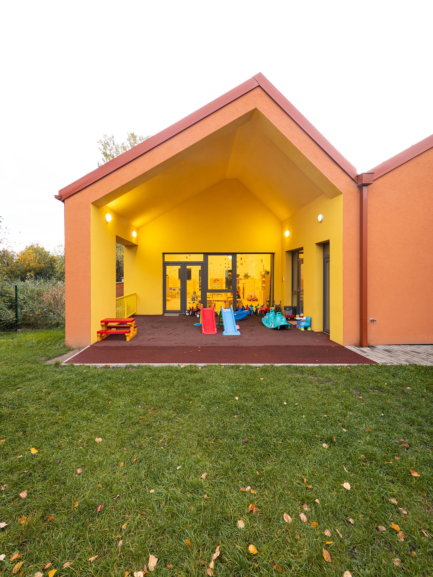 Az udvar felé fokozatosan nyílik meg a tér: a hatalmas üvegajtó mögött tetővel fedett rész következik, majd egy védett, de már tágasabb kertrésszel folytatódik a kiadósabb levegőzésre