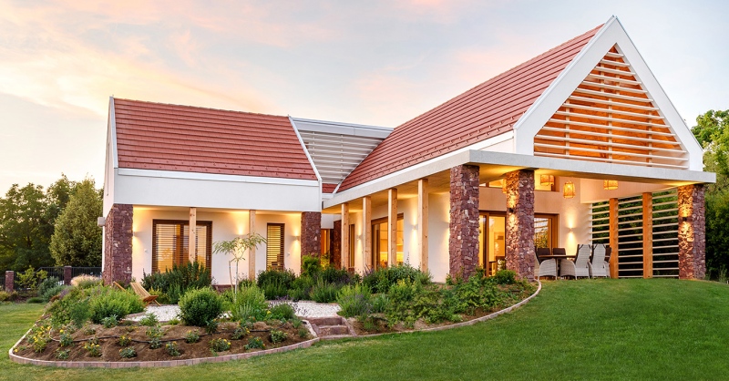 Hagyományos, vörös homokkő és kortárs látszóbeton harmonikus ötvözete egy balatoni családi házon