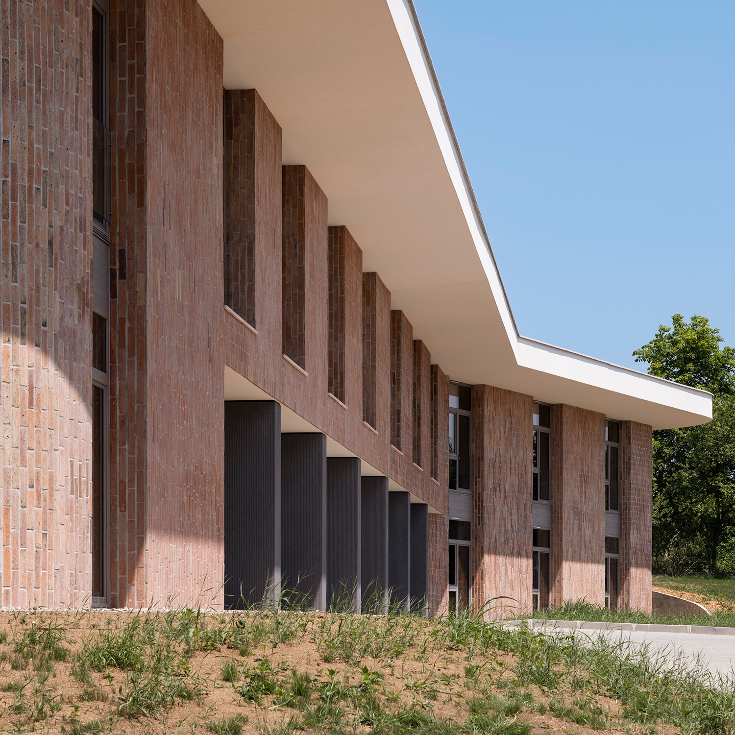Az épület nem egy nézetre komponált, minden oldalról egy-egy új főhomlokzat fogad. A bejárat azonban a déli oldalra került, ahol a szálcement burkolatú, széles pilléreken átjutva, a felső megnyitásokkal teremtenek bensőséges fogadtatást.