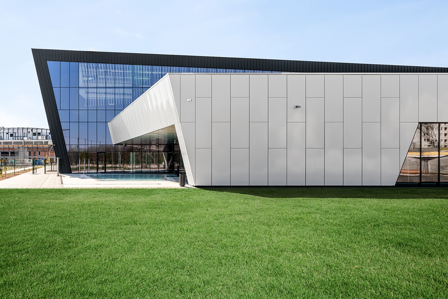 A főtömb lendületes kiszögellése az úszás előrenyúló mozzanatát ragadja meg és rögzíti állóképpé