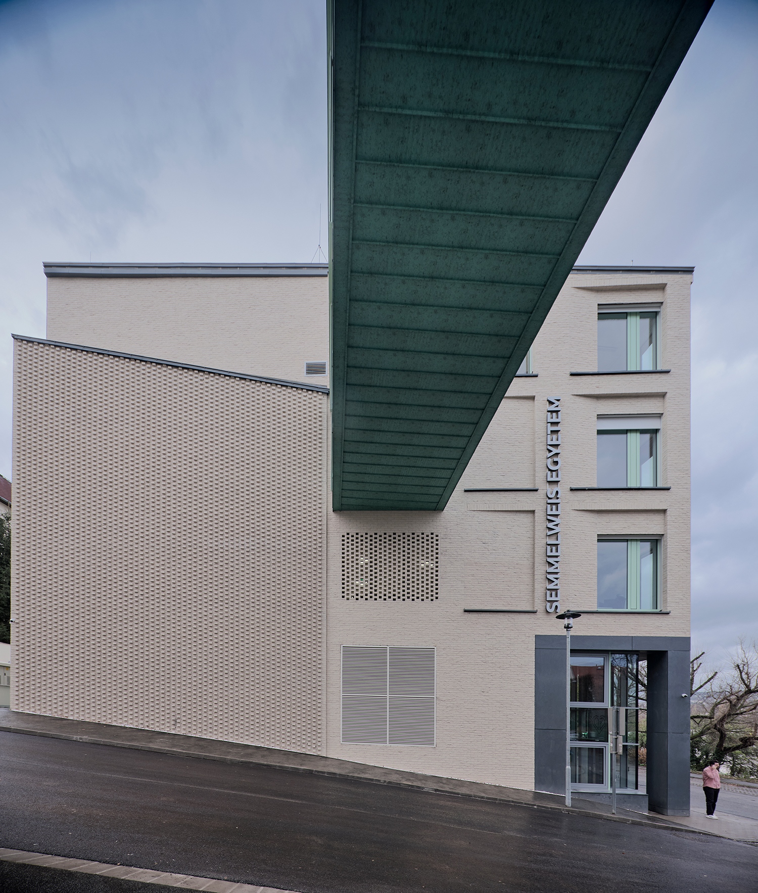 A járóbeteg ellátás a felső szintek lábaként áll le a Városmajor utca és Acsády Ignác utca sarkára. Ezt a felosztást vetíti ki a homlokzatburkolat váltása is.