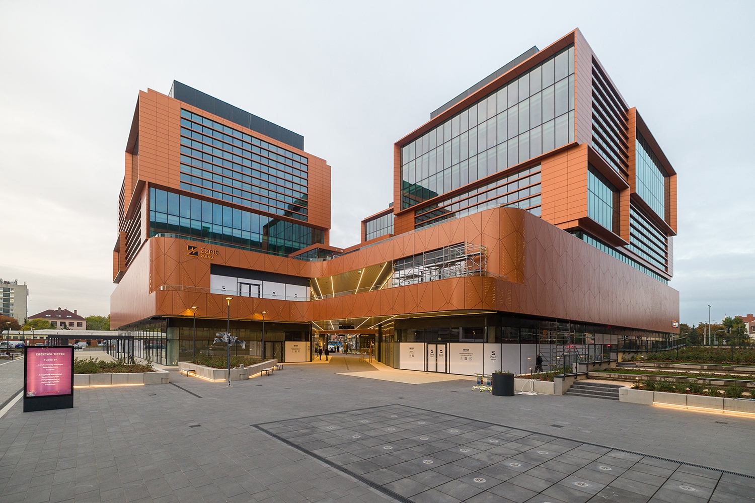 A bevásárlóutca & irodaépület gyalogos fő megközelítési iránya a Csömöri út és a Mosztár utca sarka felől van. Innen egy passzázson keresztül jutunk a földszinten kialakított üzlethelyiségek által közrefogott átriumba.