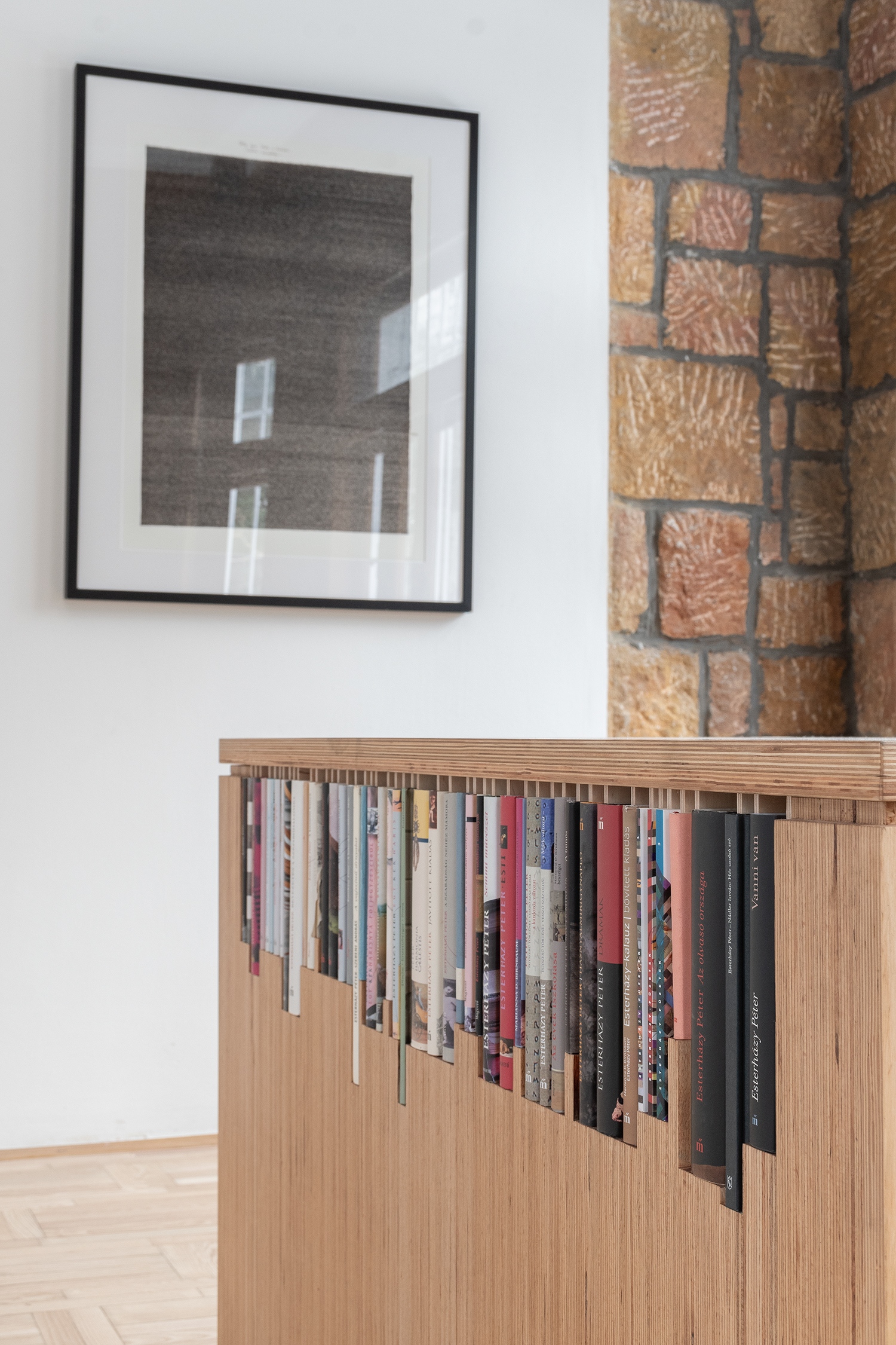 ...benne a többségében a szobában született magyar nyelvű kötetek egyedi méretűre szabott réseivel, a fordítások jelentős részének nyitott polcával, a barokk íróasztal kalandos kontúrjának intarziájával. A falakon a híres Iskola a határonmásolat egyetlen eredeti másodpéldánya.