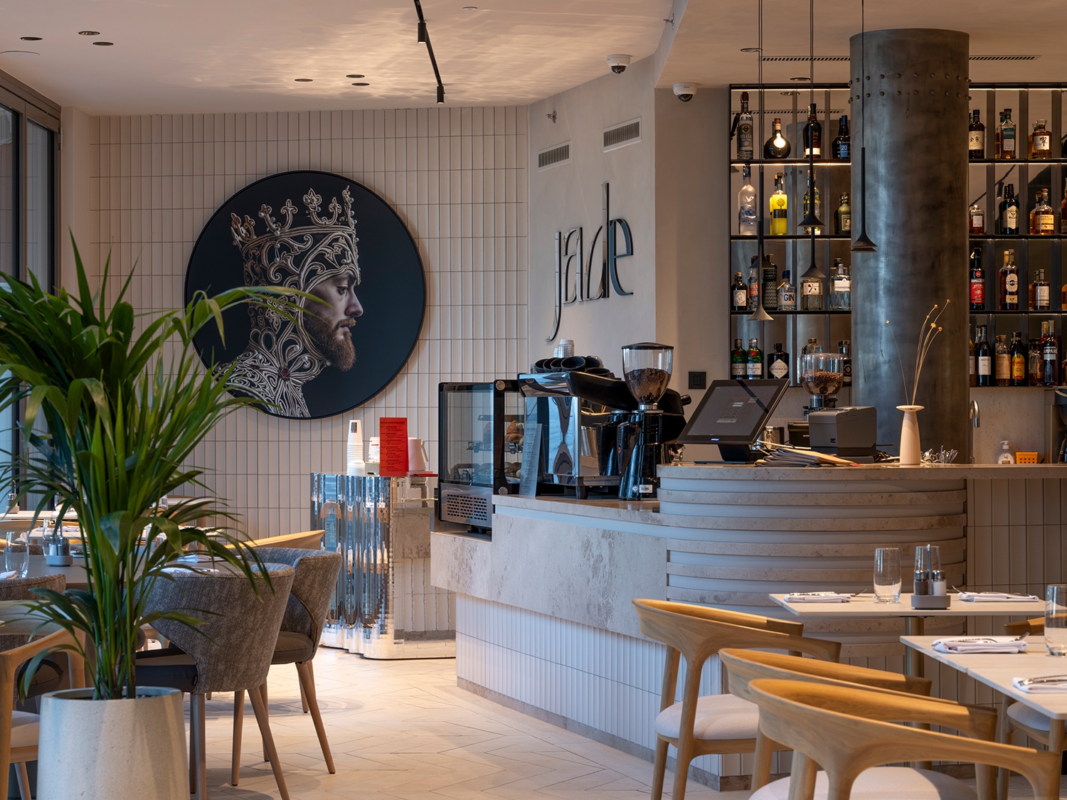 A földszintre helyezett Leon Café összekapcsolja a funkciót az utcafronttal. A világos burkolatok jól harmonizálnak a természetes anyagú bútorokkal, a törtfehér árnyalatok visszafogott eleganciát teremtenek a térben.