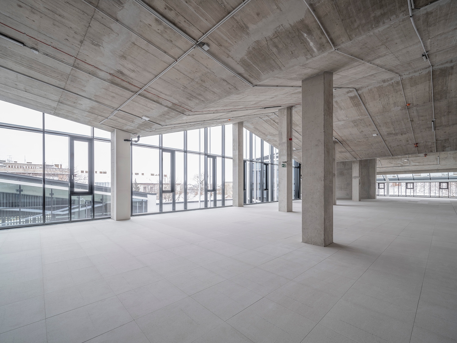 Bár az elbontott hátsó szárny vasbetonfödémét el kellett bontani, az új épületegyüttes városi sziluettre reflektáló tetőszerkezete az új belső födém esetében is frappánsan visszaköszön