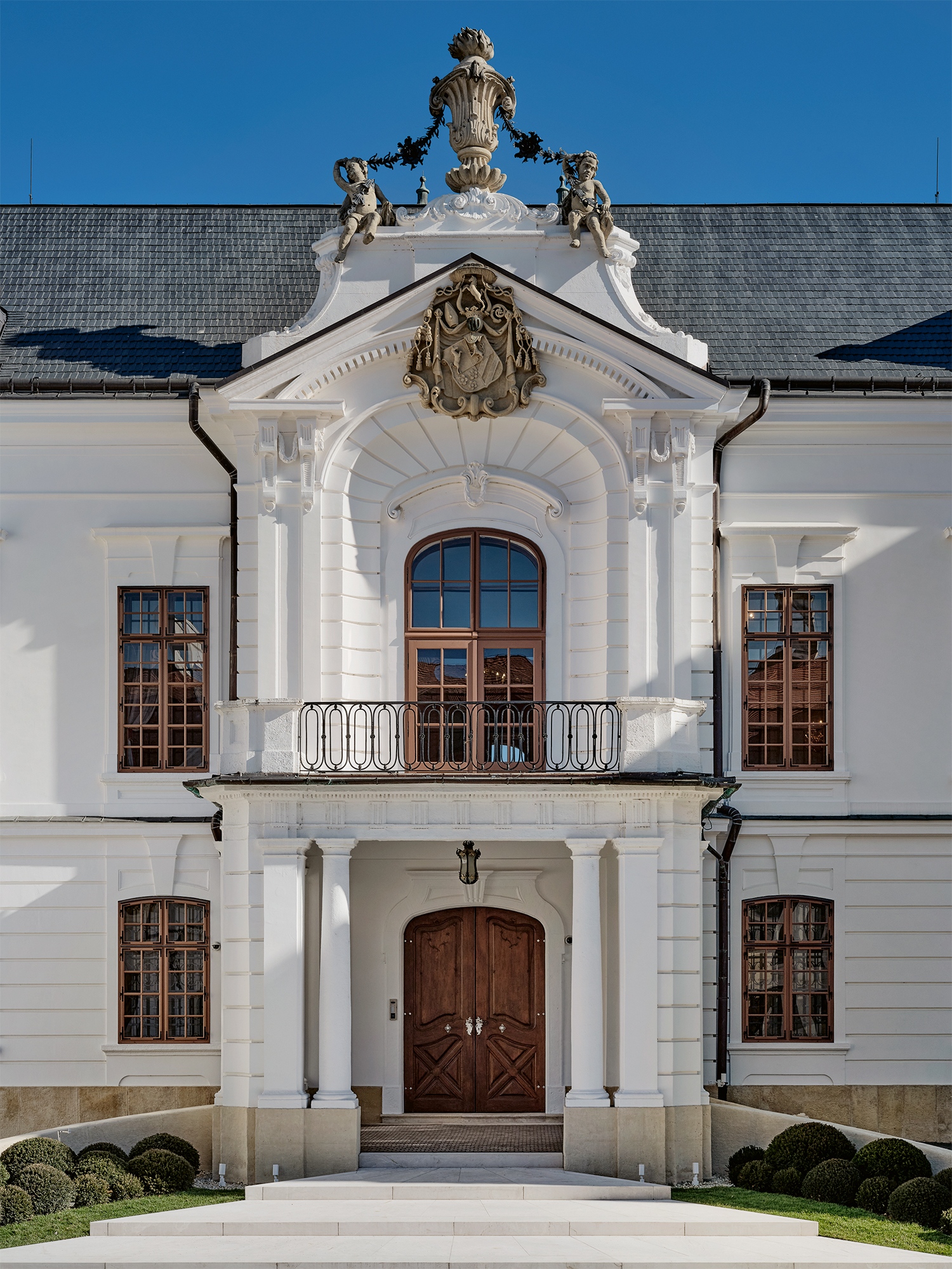 A kváderezett középrizalit porte-cochère en niche motívummal, valamint Koller Ignác címerével lett díszítve